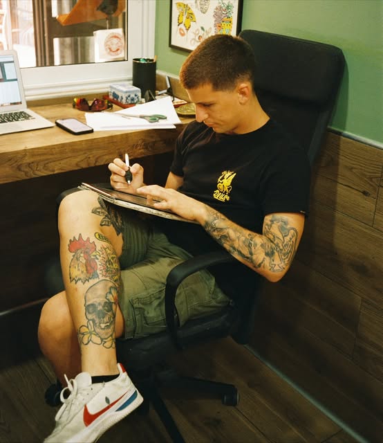 Tatuatore al lavoro su un disegno nello studio